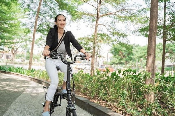 微笑的女商人骑着她的折叠自行车