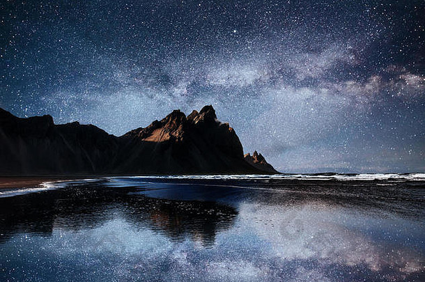 令人惊异的山反映了水布满星星的晚上斯托克斯内斯冰岛