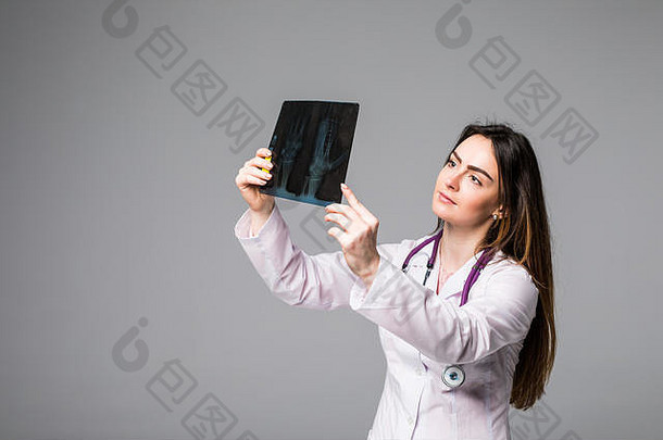 检查x光图像的女医生。焦点在x光图像上。在灰色背景上隔离。