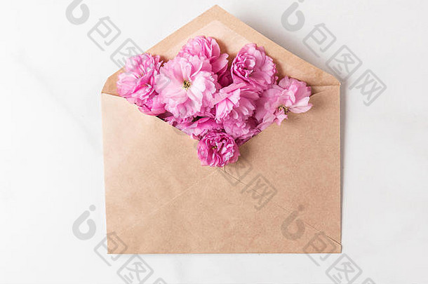 粉红色的樱花在信封里。平面布置，俯视图。假日或婚礼背景。弹簧概念