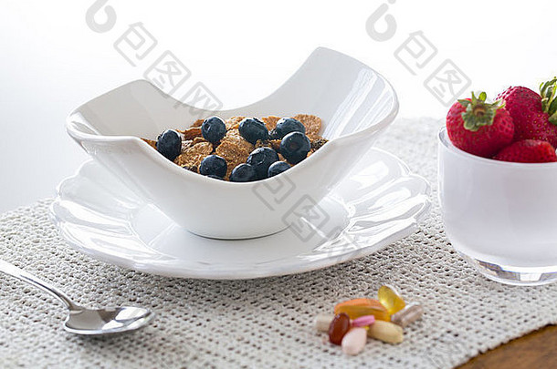蓝莓、麸皮、草莓早餐在现代陶碗中