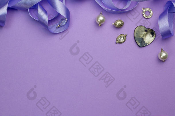 背景为银、水晶、珍珠和护身符，心形珍珠母吊坠独立于紫色缎带之上，顶部为框架