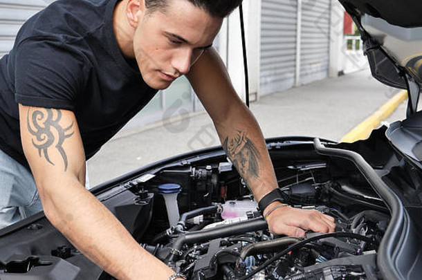 英俊的年轻人正在修理汽车发动机