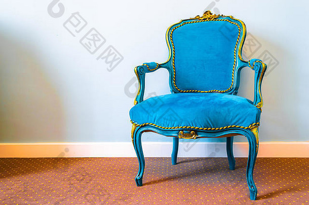 简单复古风格的椅子，蓝色织物和黄色豪华装饰，放置在带有斑点图案的棕色地毯上。左边的空格和软空格，n