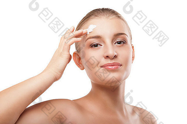 女人在脸上涂保湿霜