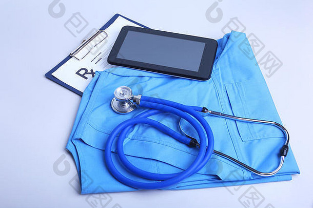 医用听诊器躺在蓝色医生的表格上，笔记本特写。治疗师的工作空间。