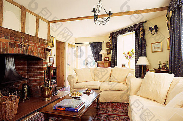 奶油沙发木咖啡表格传统的小屋厅的砖壁炉
