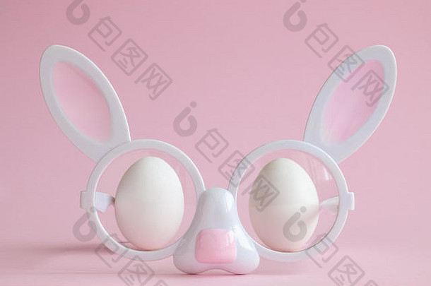 兔子脸形状的眼镜白色鸡蛋柔和的粉红色的背景最小的有创意的复活节概念