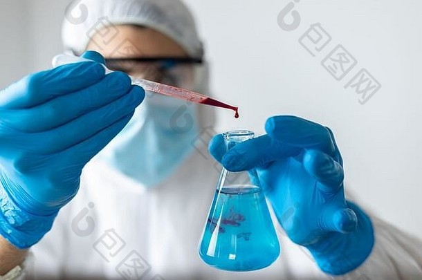 医生戴着蓝色乳胶手套和<strong>冠状病毒防护</strong>服做血液检测