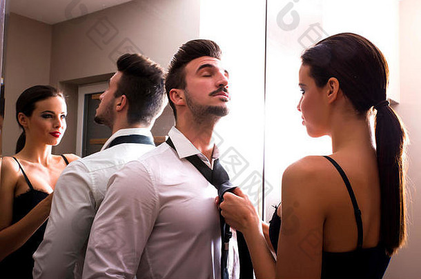 一对年轻夫妇正准备<strong>出门</strong>，准备在更衣室穿衣服。