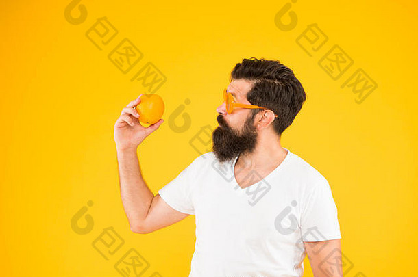 <strong>享</strong>受节食的滋味吧。节食<strong>专</strong>家拿着黄色背景上的橘子。留胡子的男人吃柑橘类水果。节食<strong>日</strong>的健康食品。