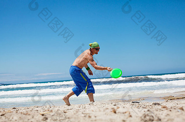 有吸引力的男人。玩弗里斯比海滩夏天体育运动健身跳