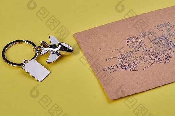 金属钥匙平面饰物和米色信封。