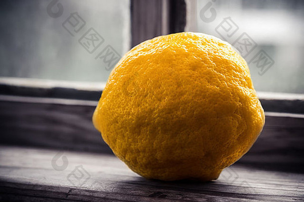 一个柠檬坐在乡村窗户的门槛上的宏观照片