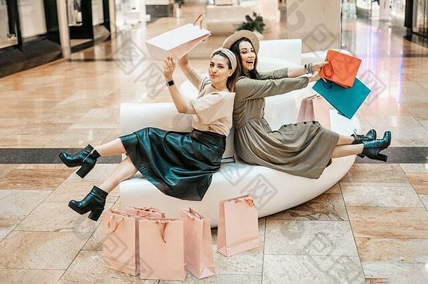 女孩们在商场的沙发上休息。购物、娱乐和休闲。<strong>抢购</strong>。