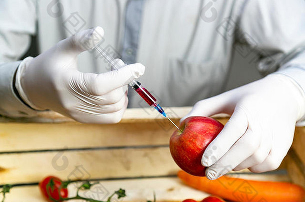 一名男子用注射器向桔子中注入化学物质、杀虫剂、化肥和化学物质，以延长水果的保质期