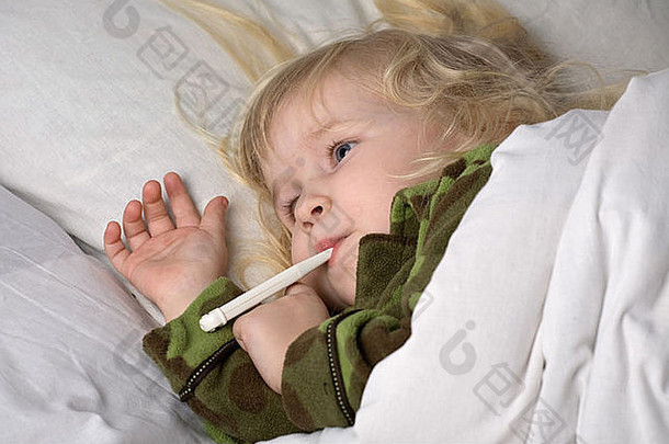 生病的孩子躺在床上，用毯子盖住，嘴里叼着温度计