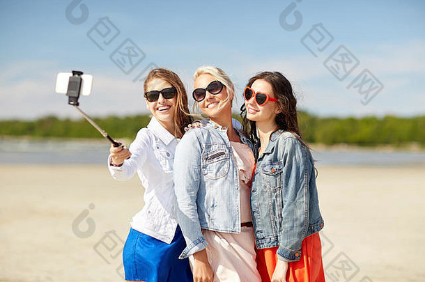 一群微笑的女人在海滩上自拍