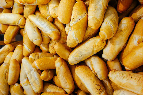 面包店货架上有不同的面包。超市或批量生产的新鲜面包卷。