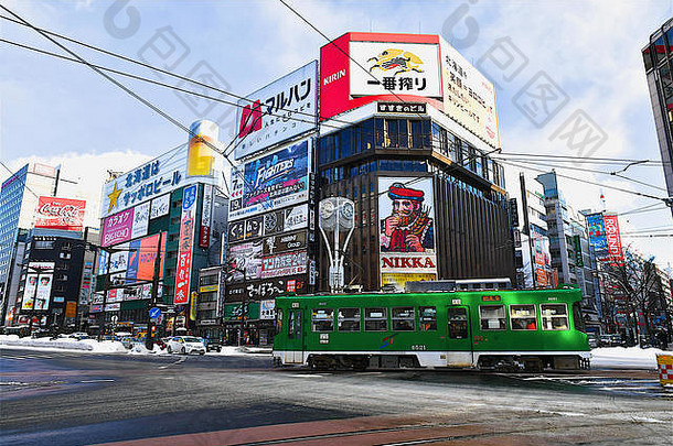 视图角落里现代建筑色彩斑斓的广告显示绿色火车通过前面札幌