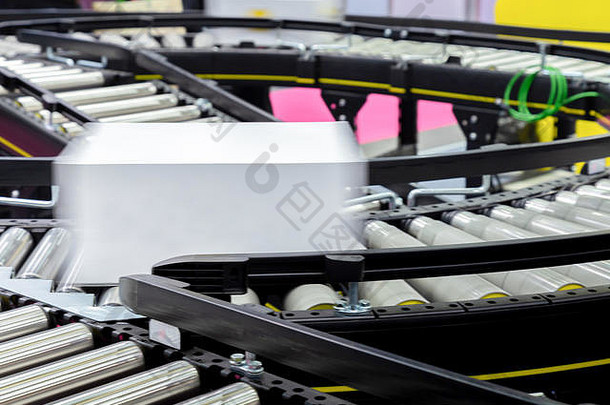产品包装的白色纸板箱在厂自动包装机的传送带上移动，准备分发给marke