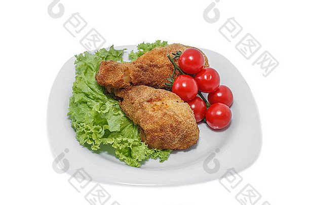 用生菜和西红柿放在盘子上的炸鸡片。在一片白色塑料上拍摄。