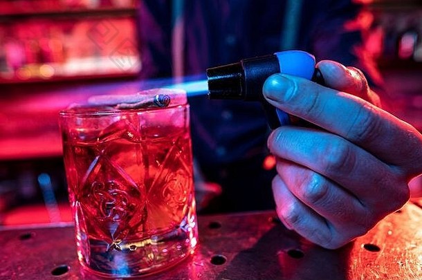 酒精鸡尾酒、饮料、饮料的特写镜头，由专业酒吧招待在五彩霓虹灯下准备。娱乐、饮料、服务理念。<strong>现代</strong>酒吧、<strong>新潮</strong>色彩、文案空间。