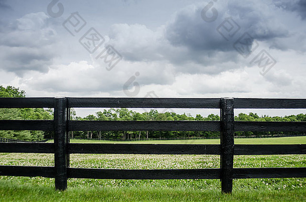 夏天暴风雨前，沿着马牧场的黑色油漆栅栏
