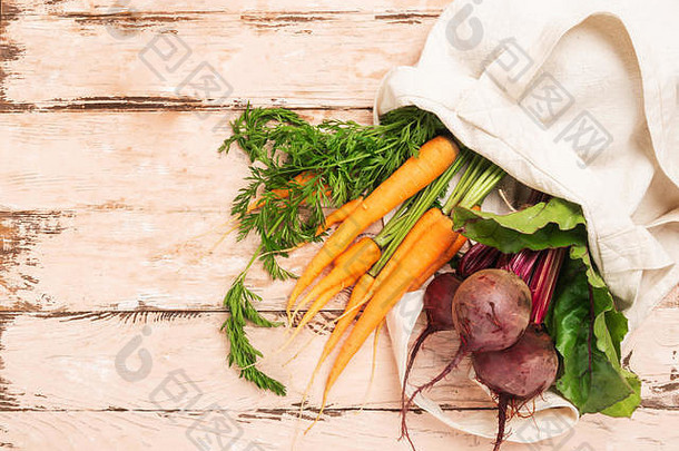 新鲜天然有机胡萝卜甜菜袋由纯棉木制乡村背景制成。天然环保产品概念。