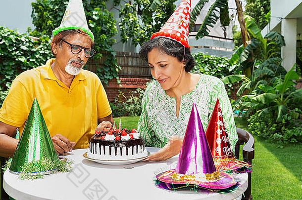这对幸福的老年夫妇在自家花园里的55<strong>周年庆</strong>典上切蛋糕