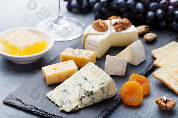 以现代切菜<strong>板</strong>为背景，搭配蜂蜜、坚果和葡萄的奶酪。