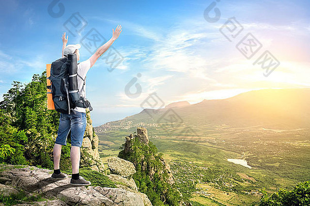 背着背包的游客可以从山顶欣赏山谷景色