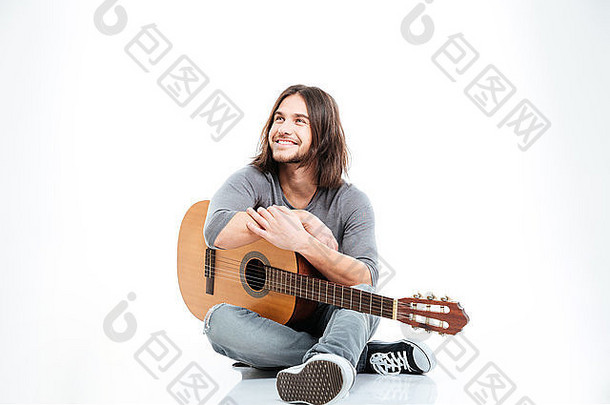 快乐的英俊的年轻的男人。长头发微笑持有吉他白色背景