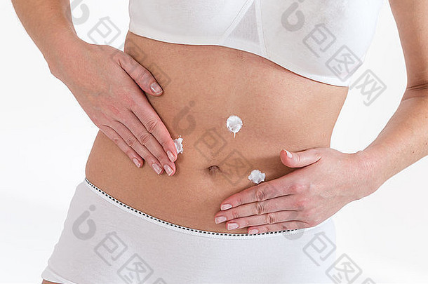 女人应用身体奶油腹部孤立的白色背景