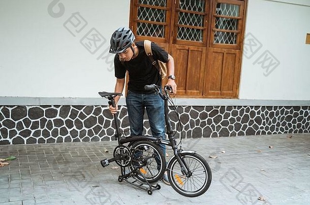 亚洲男人。褶皱<strong>折叠自行车</strong>准备工作前面房子