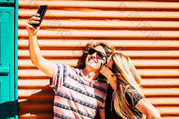 现代年轻人的爱情和关系使用现代智能手机接吻和自拍-社交媒体和prett每日邮报概念