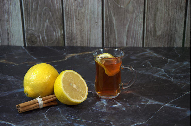 玻璃杯柠檬茶肉桂棒一半成熟的柠檬