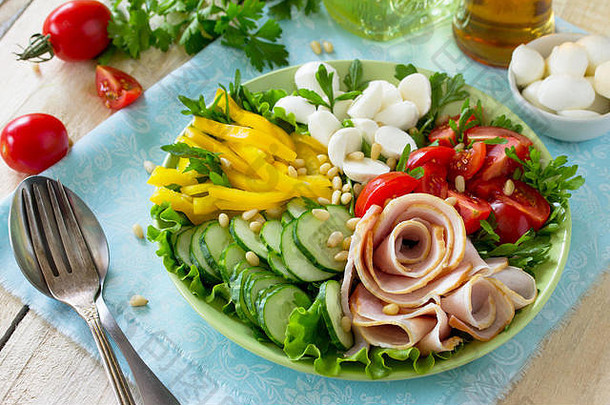 夏季沙拉配醋醋沙拉酱。沙拉配火腿、新鲜蔬菜、松仁和马苏里拉。