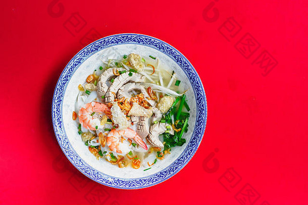 一套越南面条，配猪肉和虾，红毯上的汤碗，配酱汁和青柠檬。