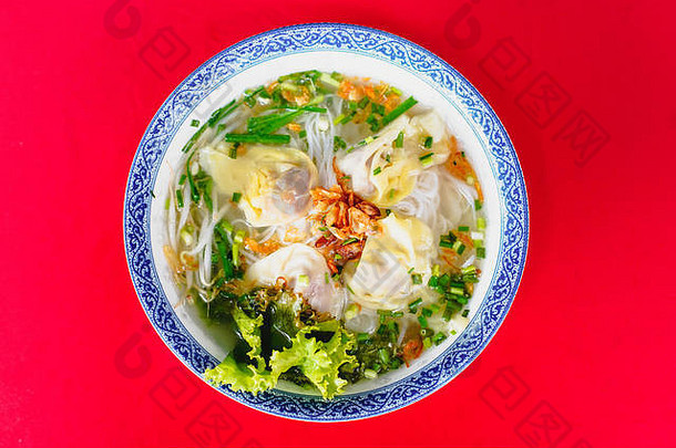 一套越南面条，配猪肉和虾，红毯上的汤碗，配酱汁和青柠檬。