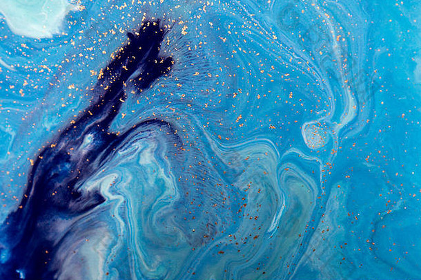 大理石蓝色抽象背景和金色亮片。液体大理石墨水图案。