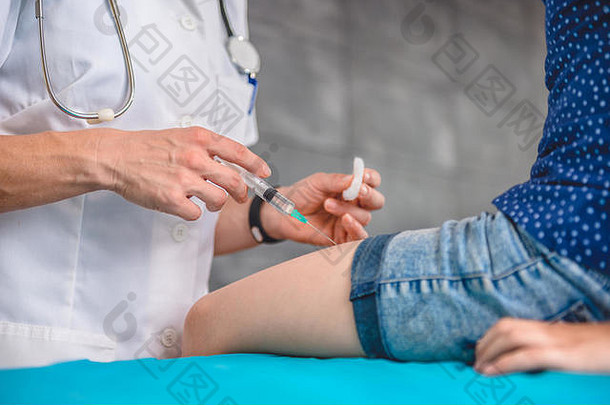 儿科女医生给年轻的女孩疫苗拍摄腿