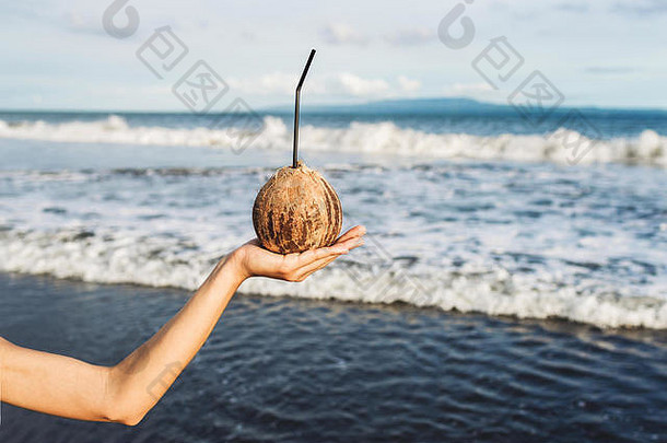 巴厘岛海边，一名女子手牵椰子。蓝色热带背景，标志空白。<strong>夏日清凉</strong>健康饮料