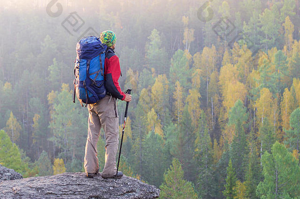 男人。背包徒步旅行波兰大手帕站岩石黎明背景秋天森林