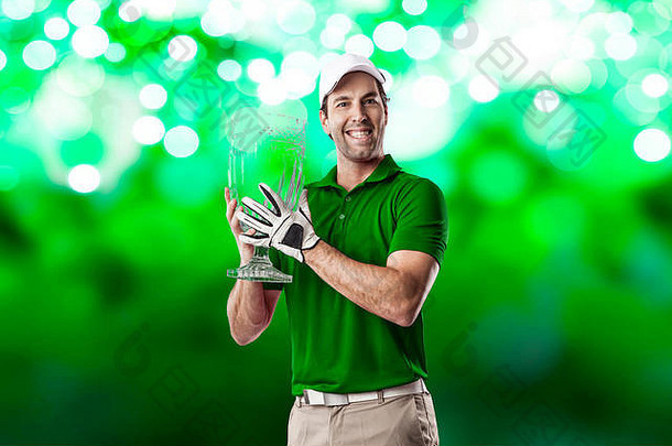 身穿绿色球衣的高尔夫运动员手拿玻璃奖杯，在绿光背景下庆祝。