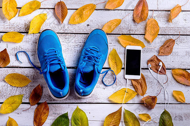 体育鞋子智能手机耳机秋天叶子白色木