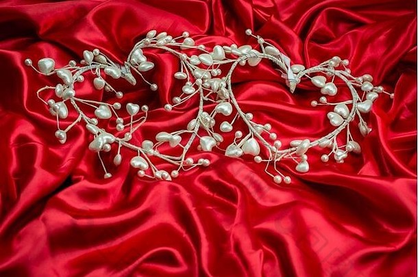 红色缎面背景，白色珍珠心形