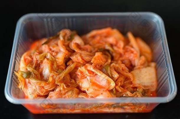 特写镜头拍摄传统的朝鲜文食物泡菜服务塑料容器水平拍摄黑色的背景