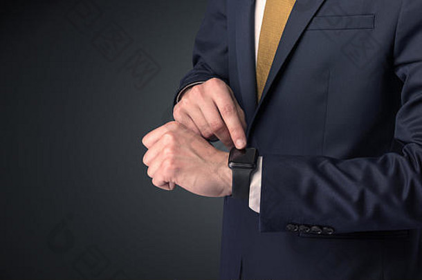一名男子穿着西装，手腕上戴着智能手表。
