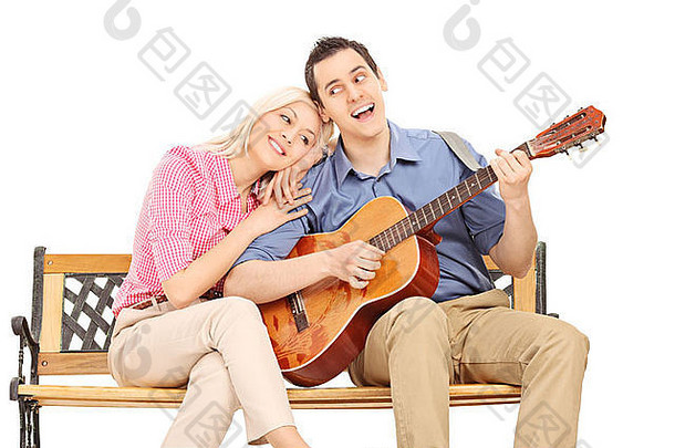 年轻的的家伙玩吉他女朋友坐着板凳上